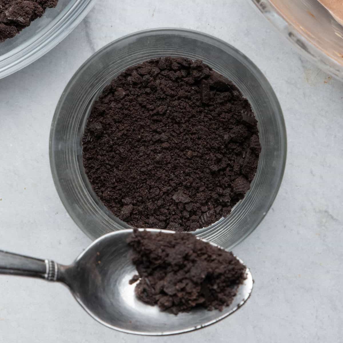 Scooping crushed cookies into jar.