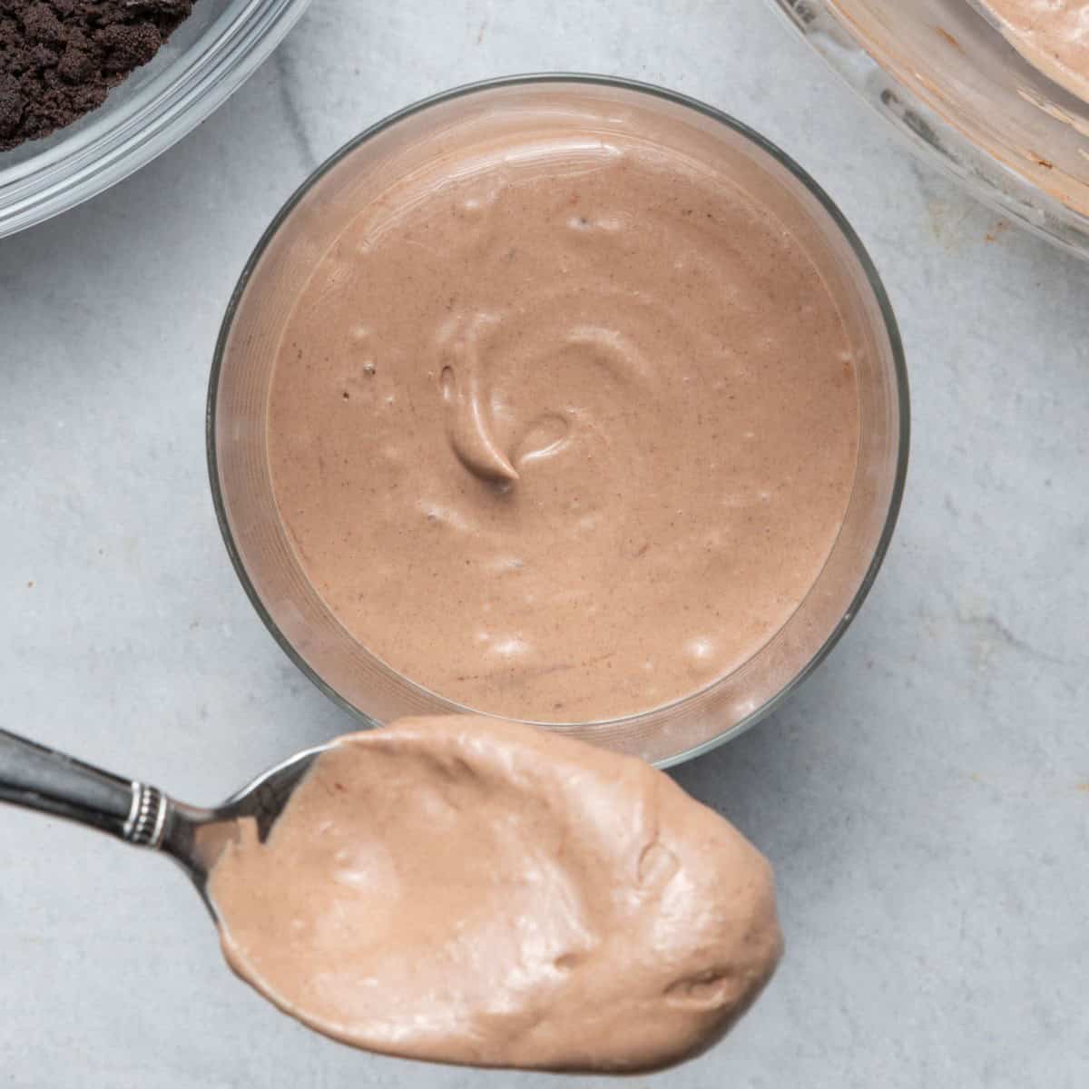 Scooping pudding into jar.