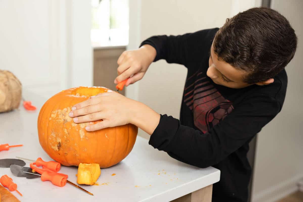 Adam carving pumpkin with tools