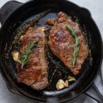 Steak cooked in cast iron skillet with rosemary and garlic