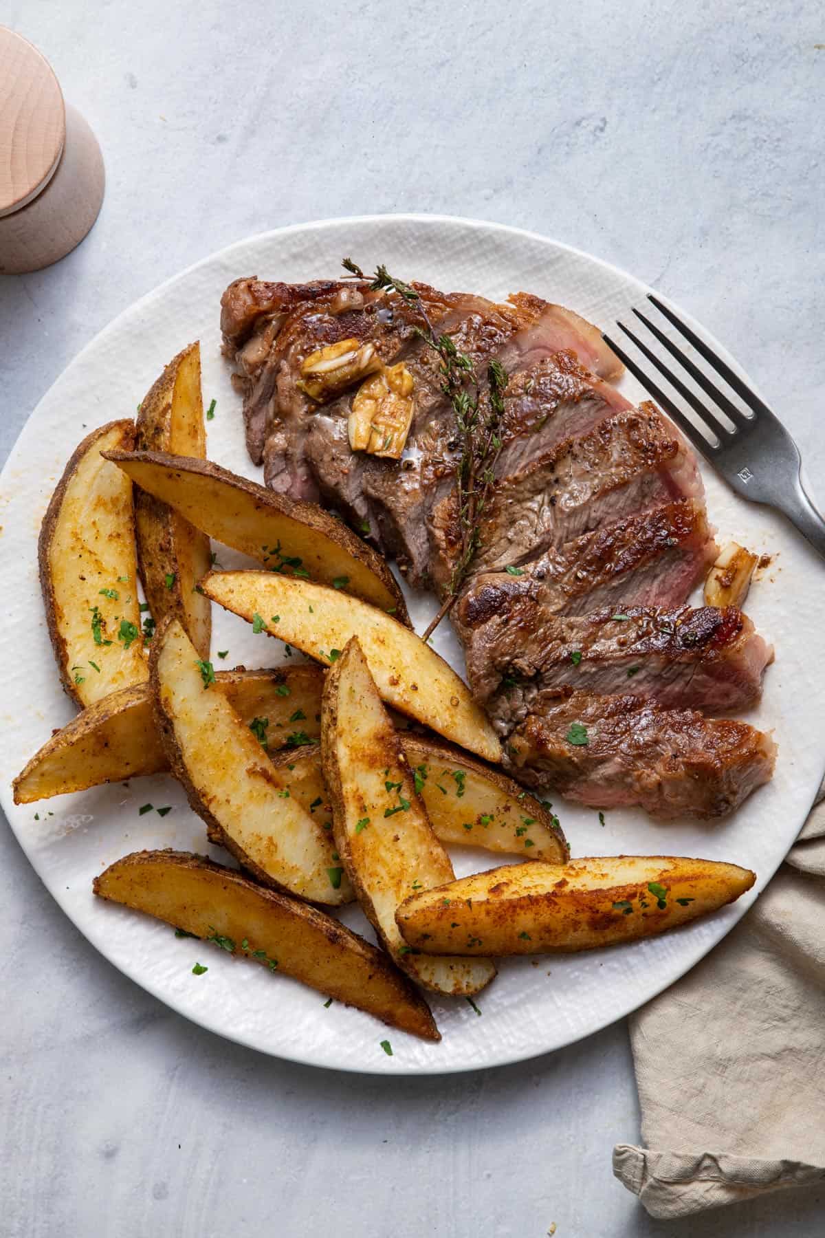 Plate of cast iron steak with oven baked fries