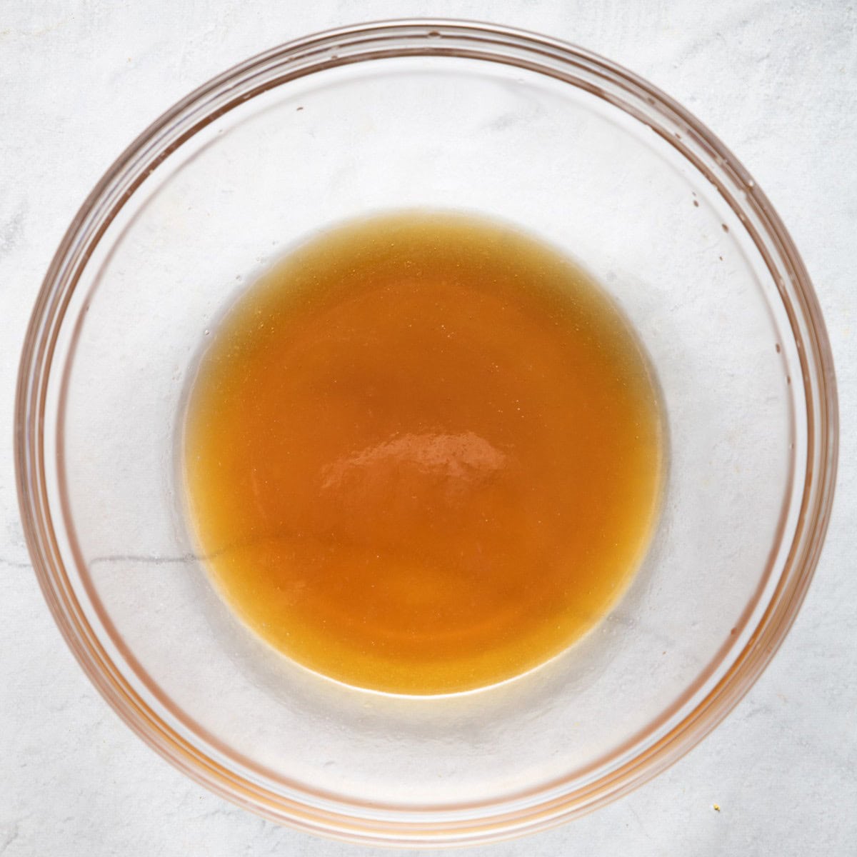 Bowl with maple syrup and melted coconut oil mixed together.