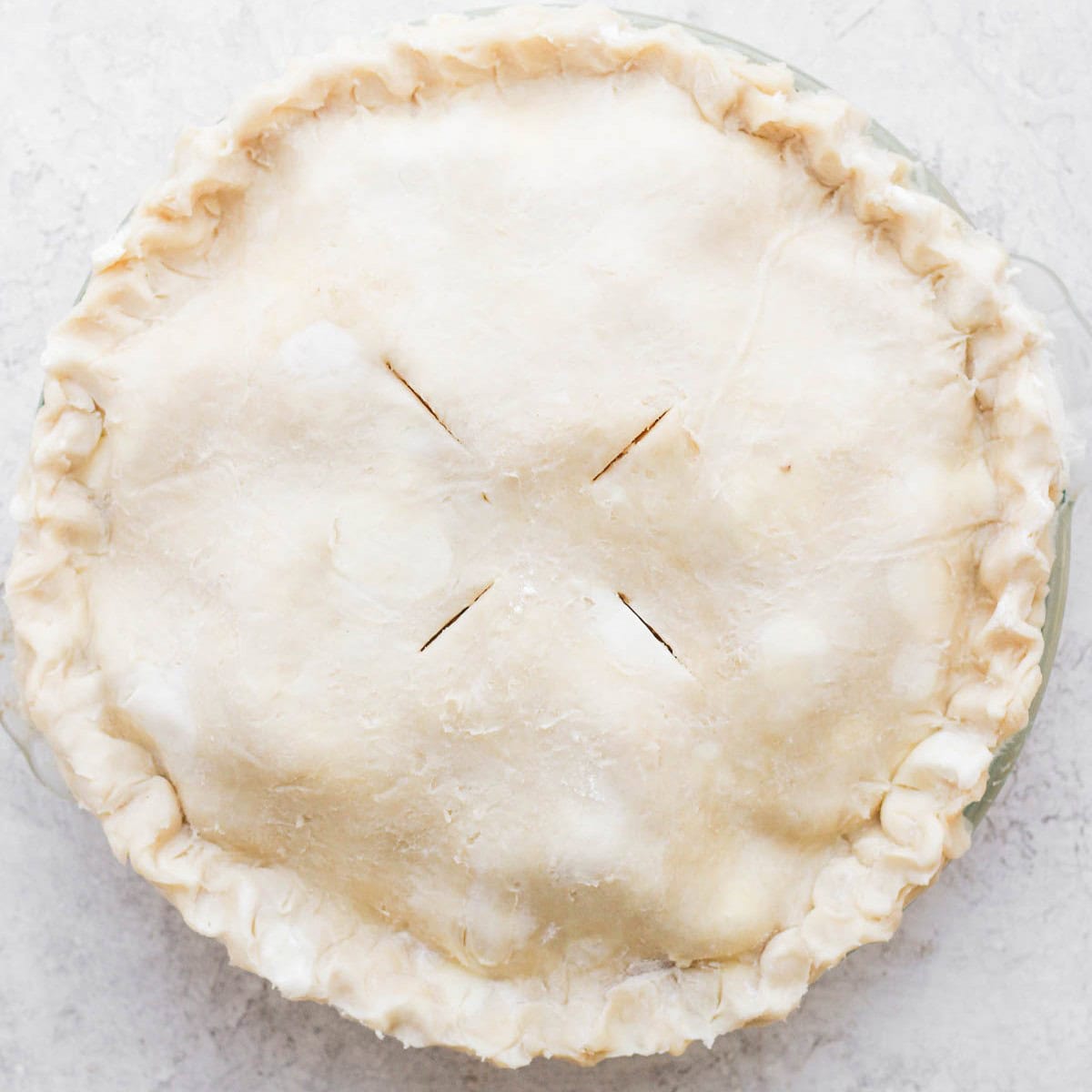 Second pie dough on top of apples with the slits cut.