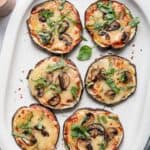 Large platter of eggplant pizza topped with mushrooms