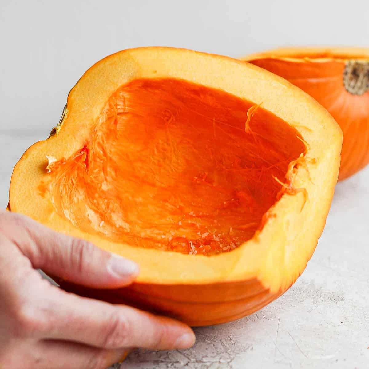 Sprinkled salt on flesh of pumpkin halves.