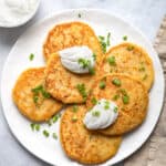 Mashed potato pancakes on a plate with sour cream