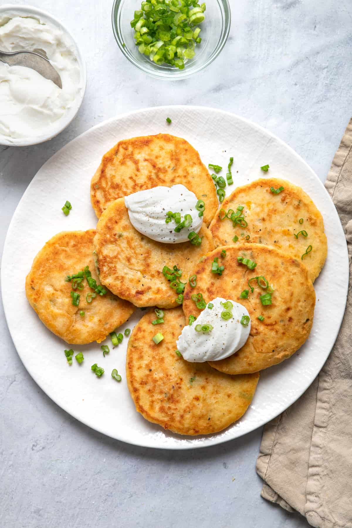 Mashed potato pancakes on a plate with sour cream