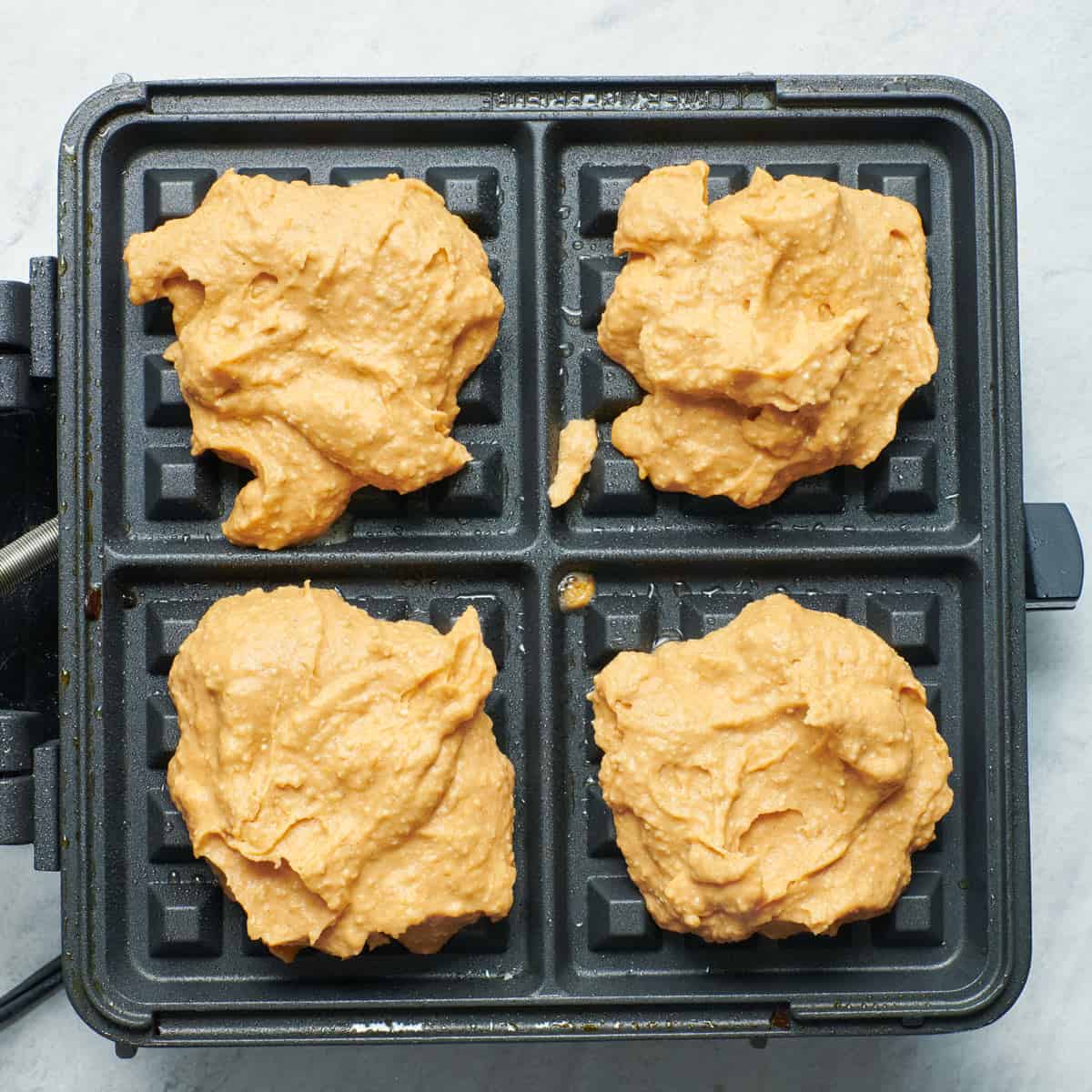 Batter in waffle iron before cooking.