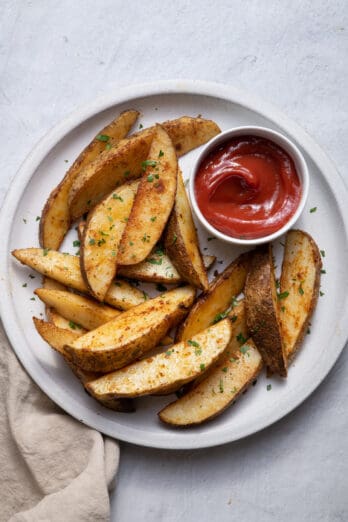 Baked potato wedges on plate with ketchup