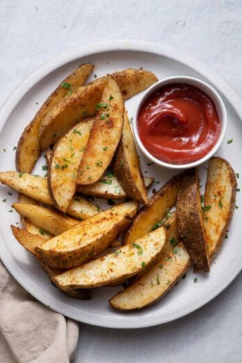 Baked potato wedges on plate with ketchup