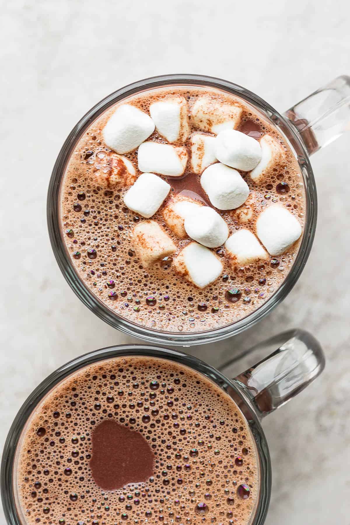Two mugs of hot chocolate, one topped with marshmallows