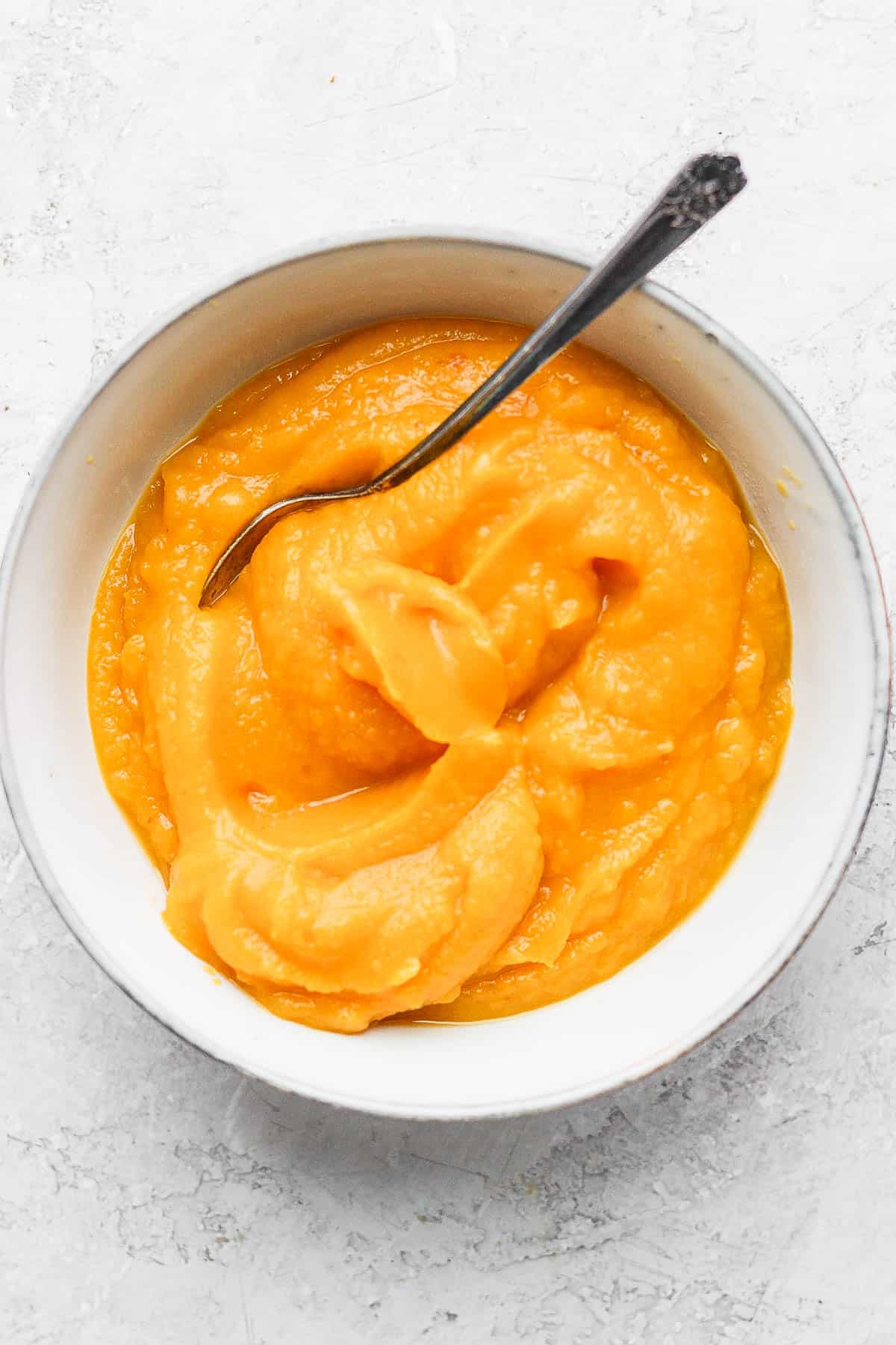 Homemade pumpkin puree from scratch in a bowl with a spoon