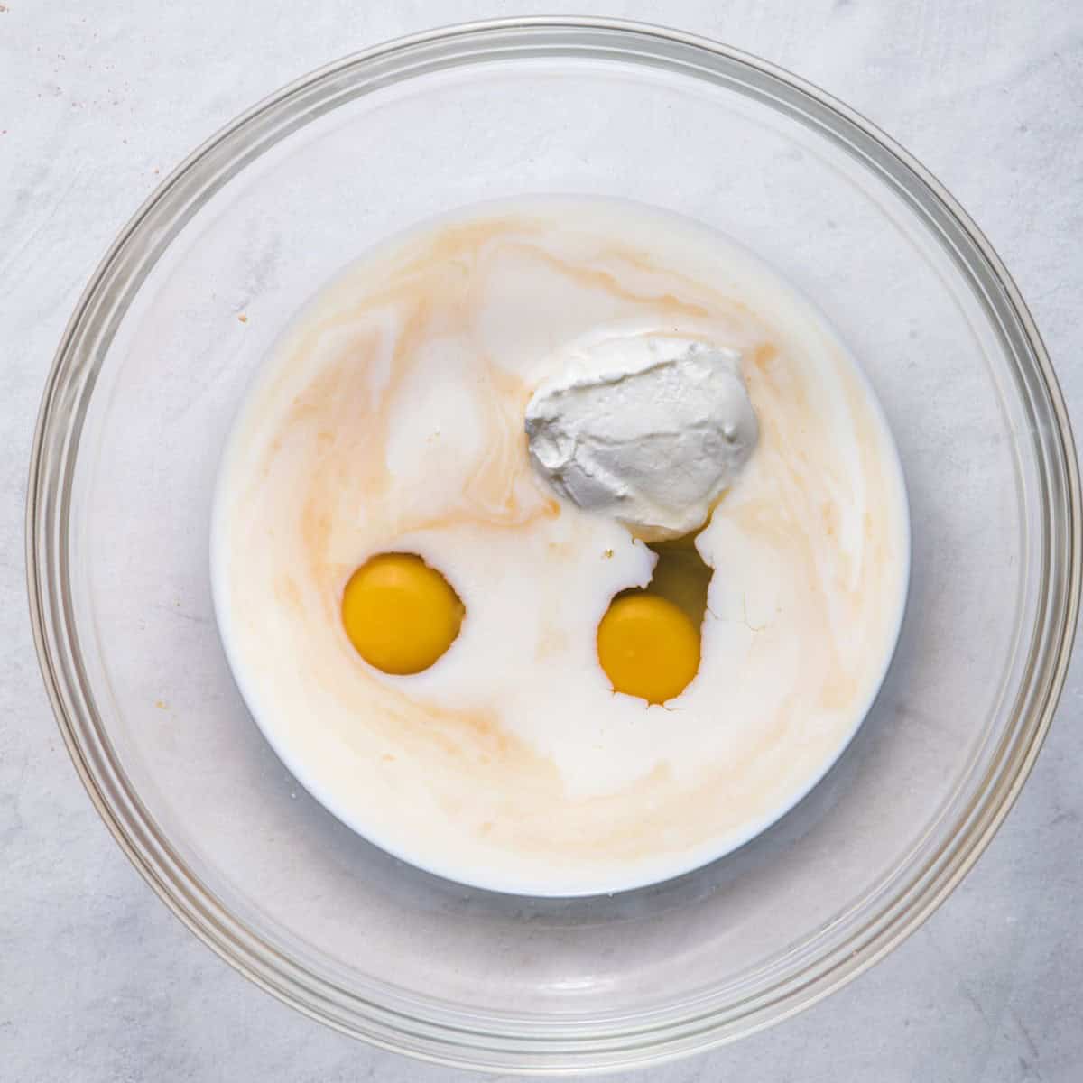 Greek yogurt, milk, eggs and vanilla in bowl.