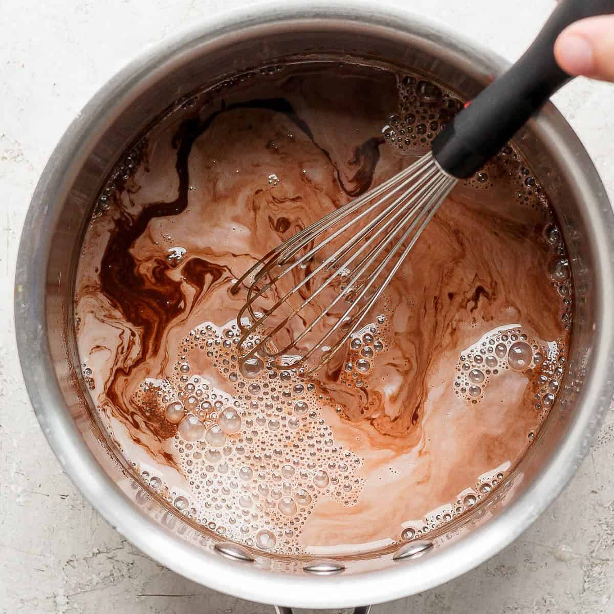 Whisking in the milk.