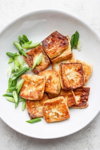 Bowl of baked tofu garnished with green onions