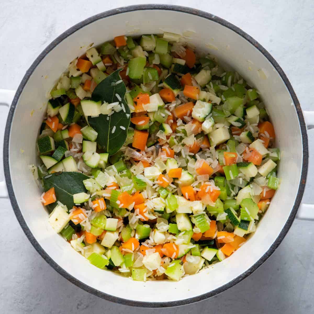 Zucchini, rice and bay leaves stirred in.