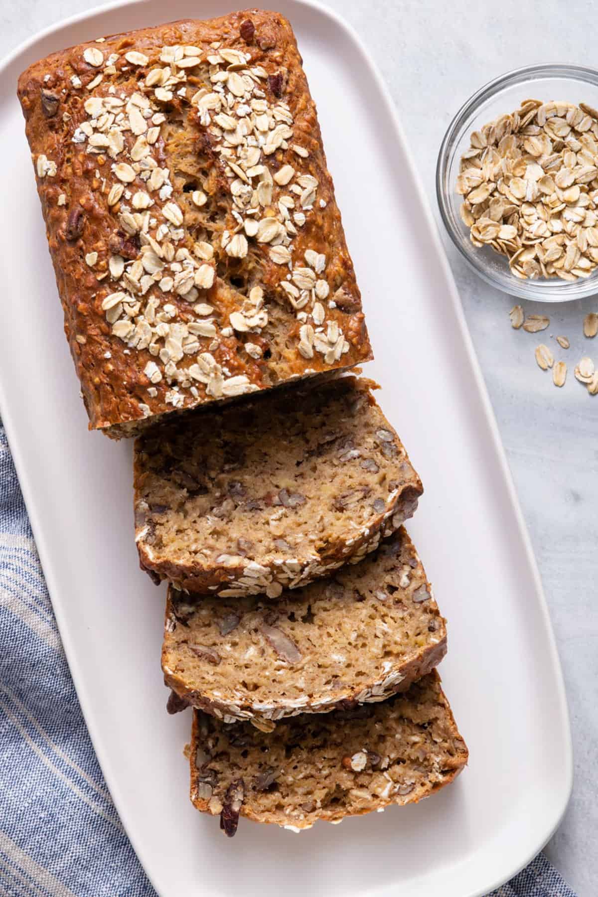 Oatmeal banana bread sliced on a long white dish