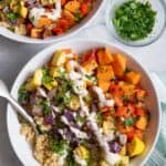 Roasted vegetable quinoa bowls topped with tahini sauce