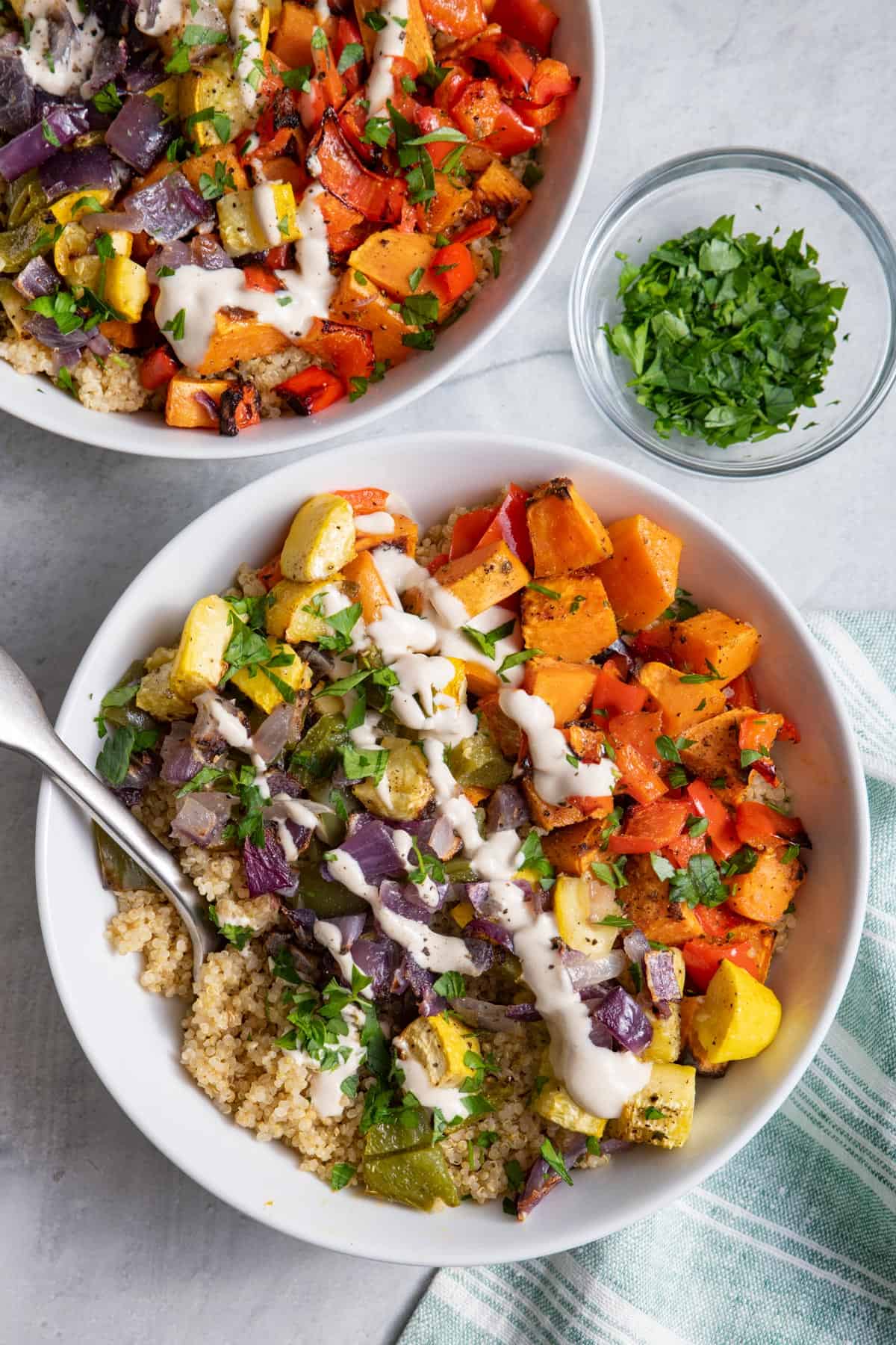 Roasted vegetable quinoa bowls topped with tahini sauce
