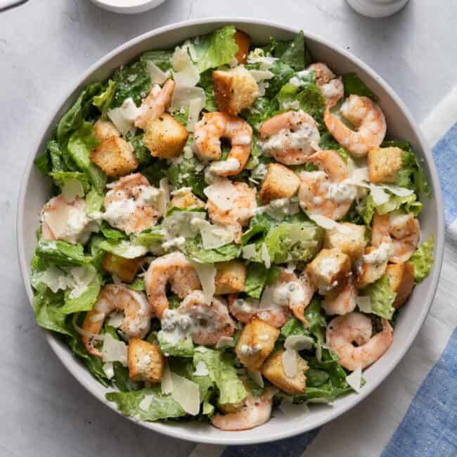 Large bowl of the salad with the dressing drizzled on top.