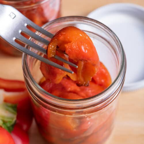 Fork lifting up roasted red bell peppers