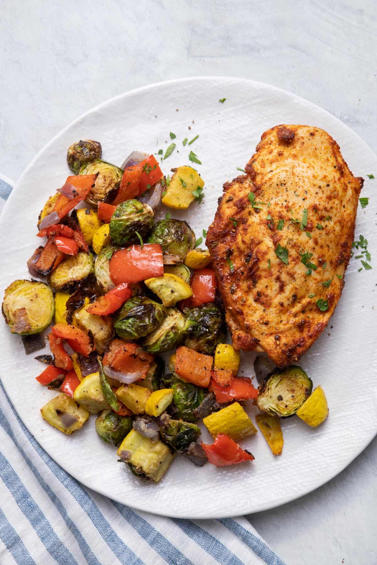 Air fryer chicken on a plate with air fryer vegetables