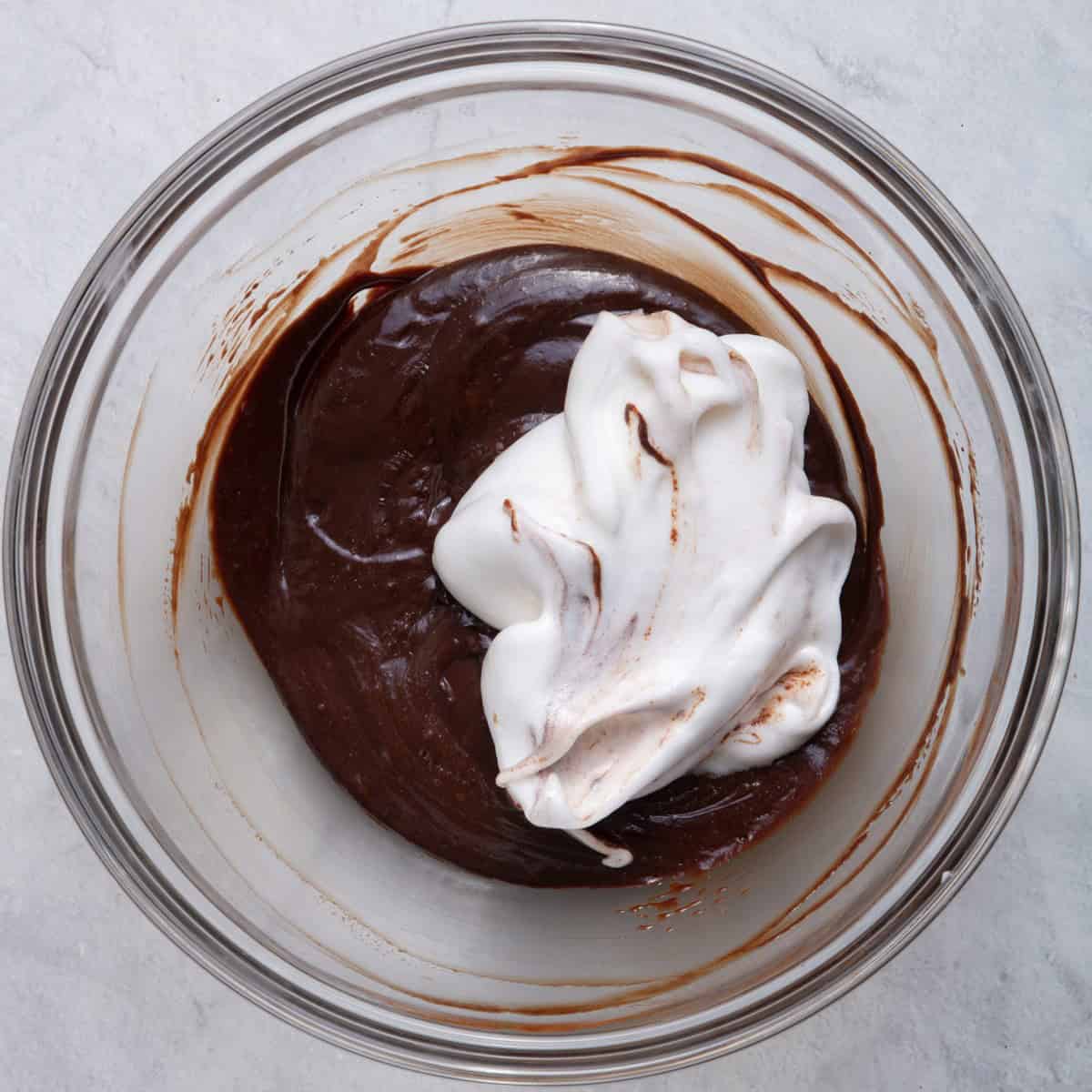 Adding about ¼ of the egg whites into chocolate mixture.