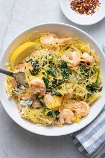 Spaghetti squash shrimp scampi finished product with crushed red pepper in small bowl