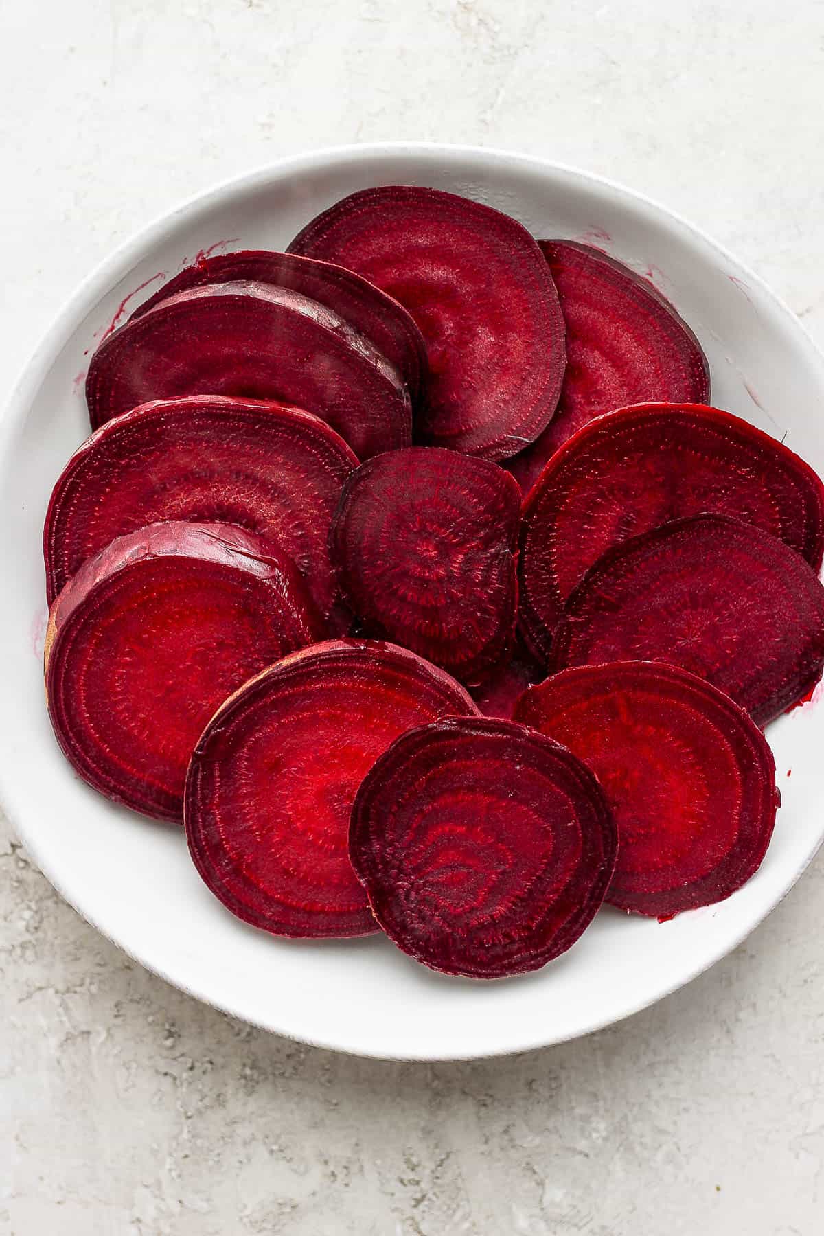 Boiled beets in white bowl sliced after cooking