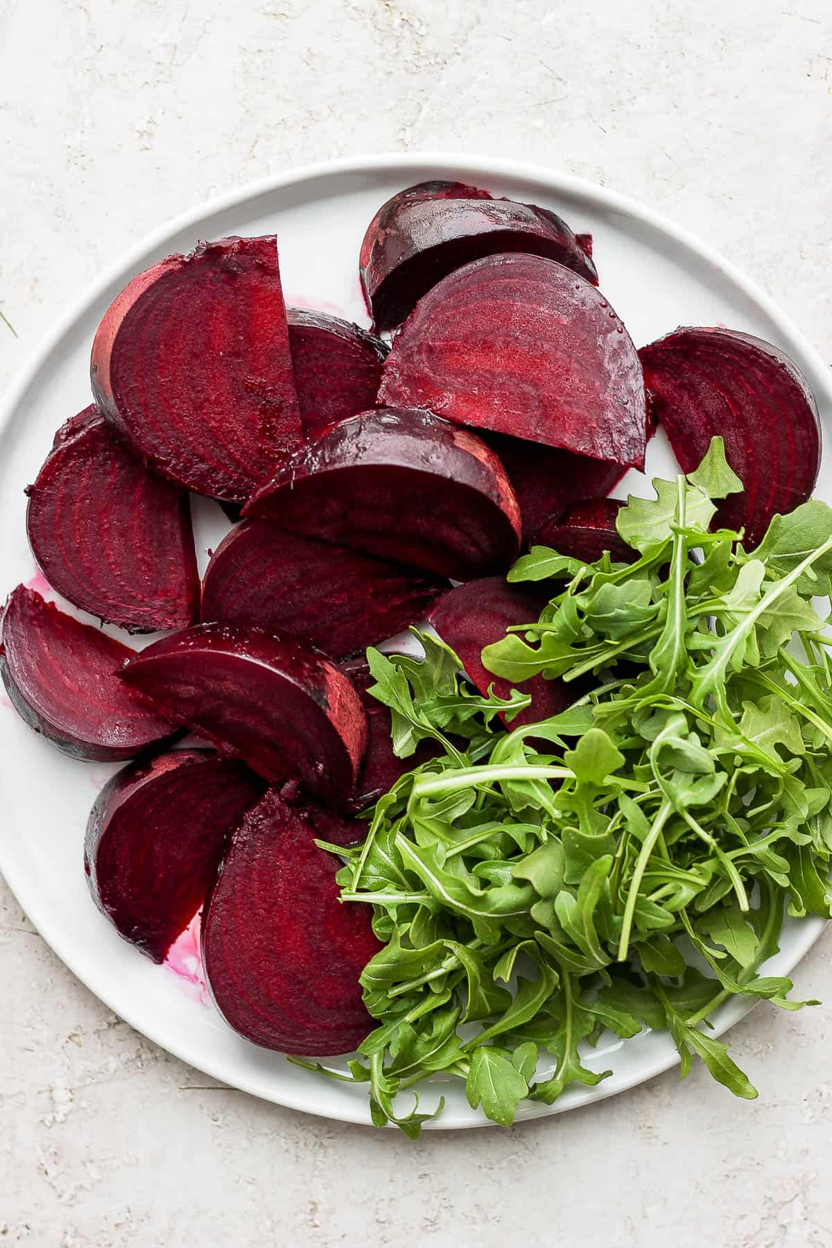 Roasted beets on white plate with arugula