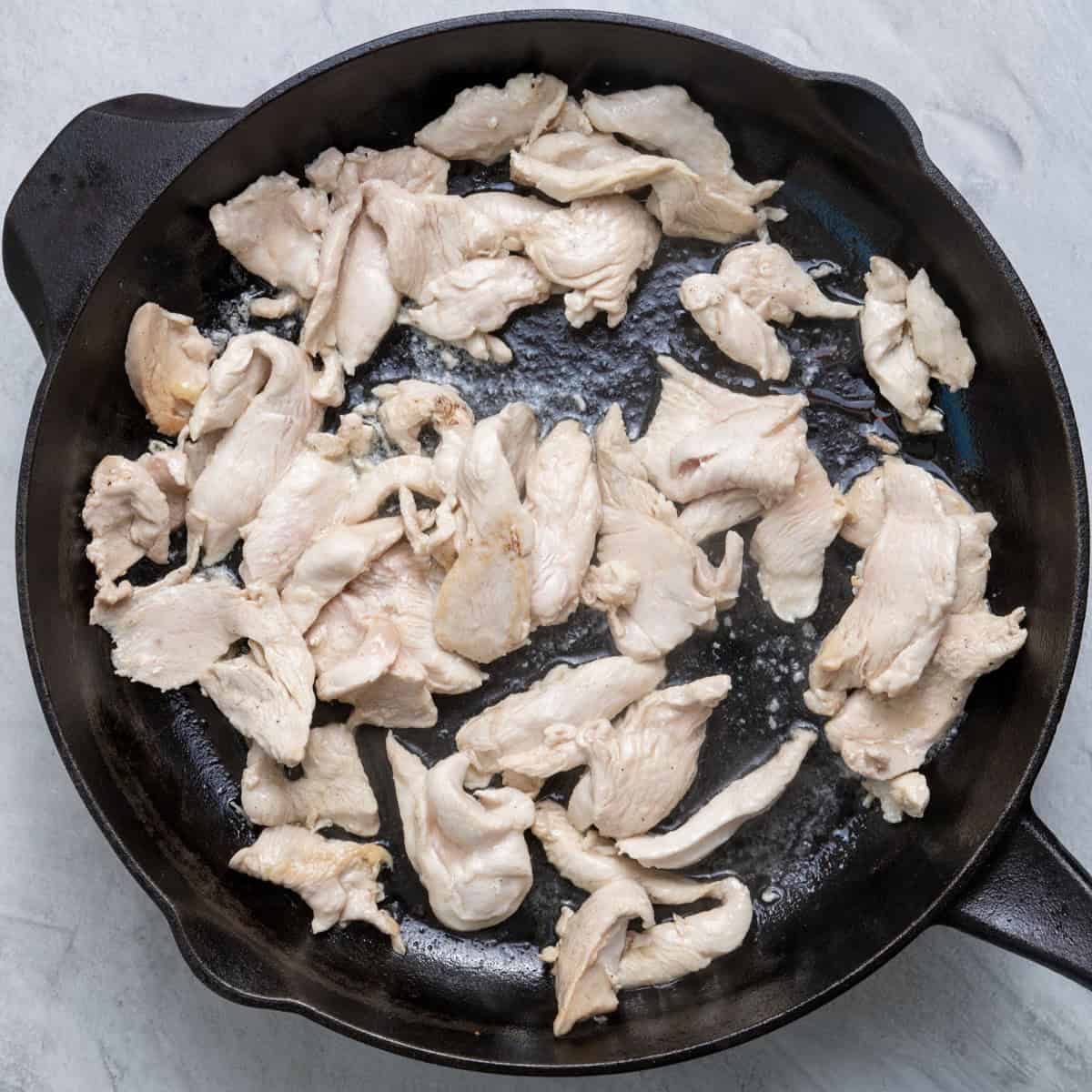Cooked chicken on skillet.