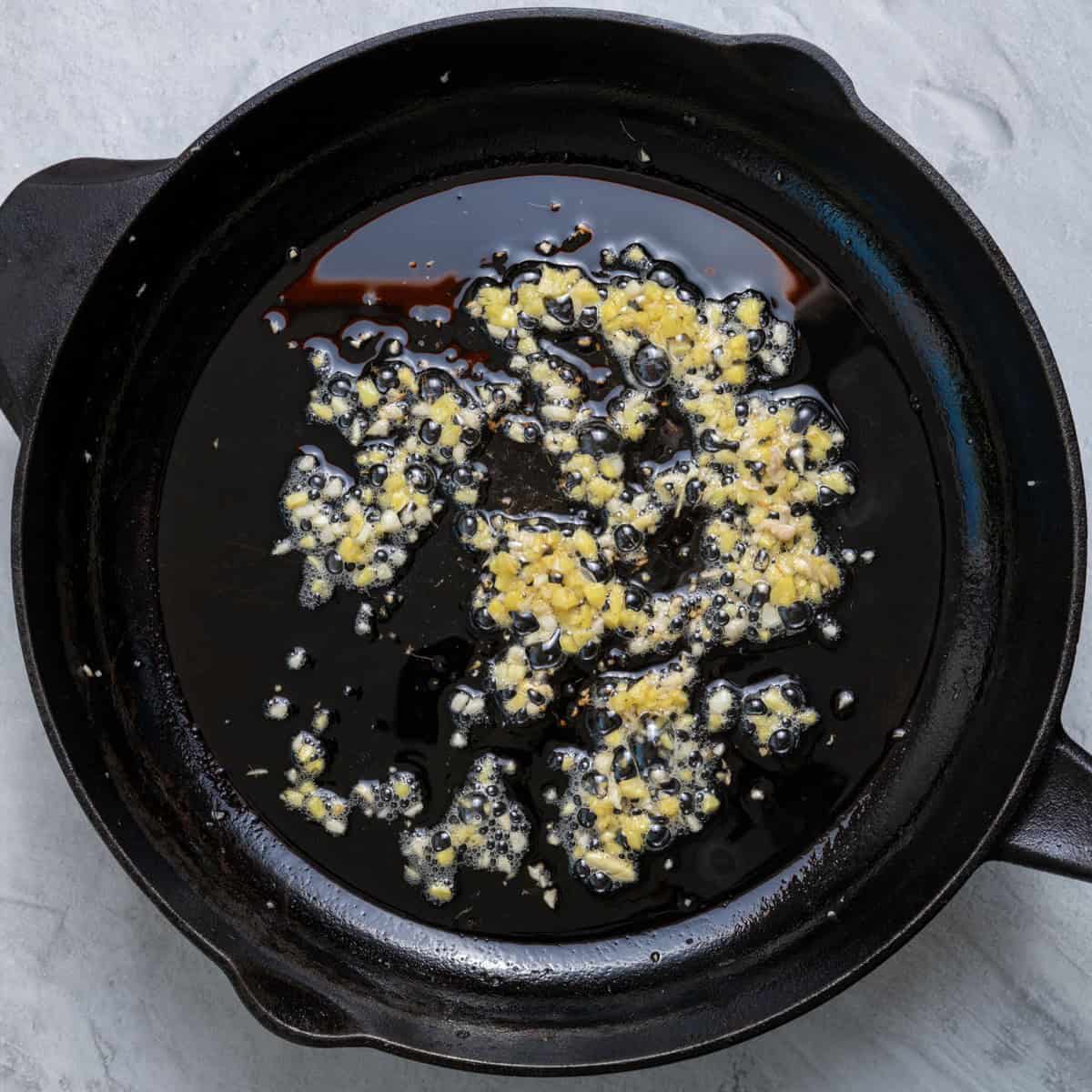 Cooked garlic and ginger on skillet.