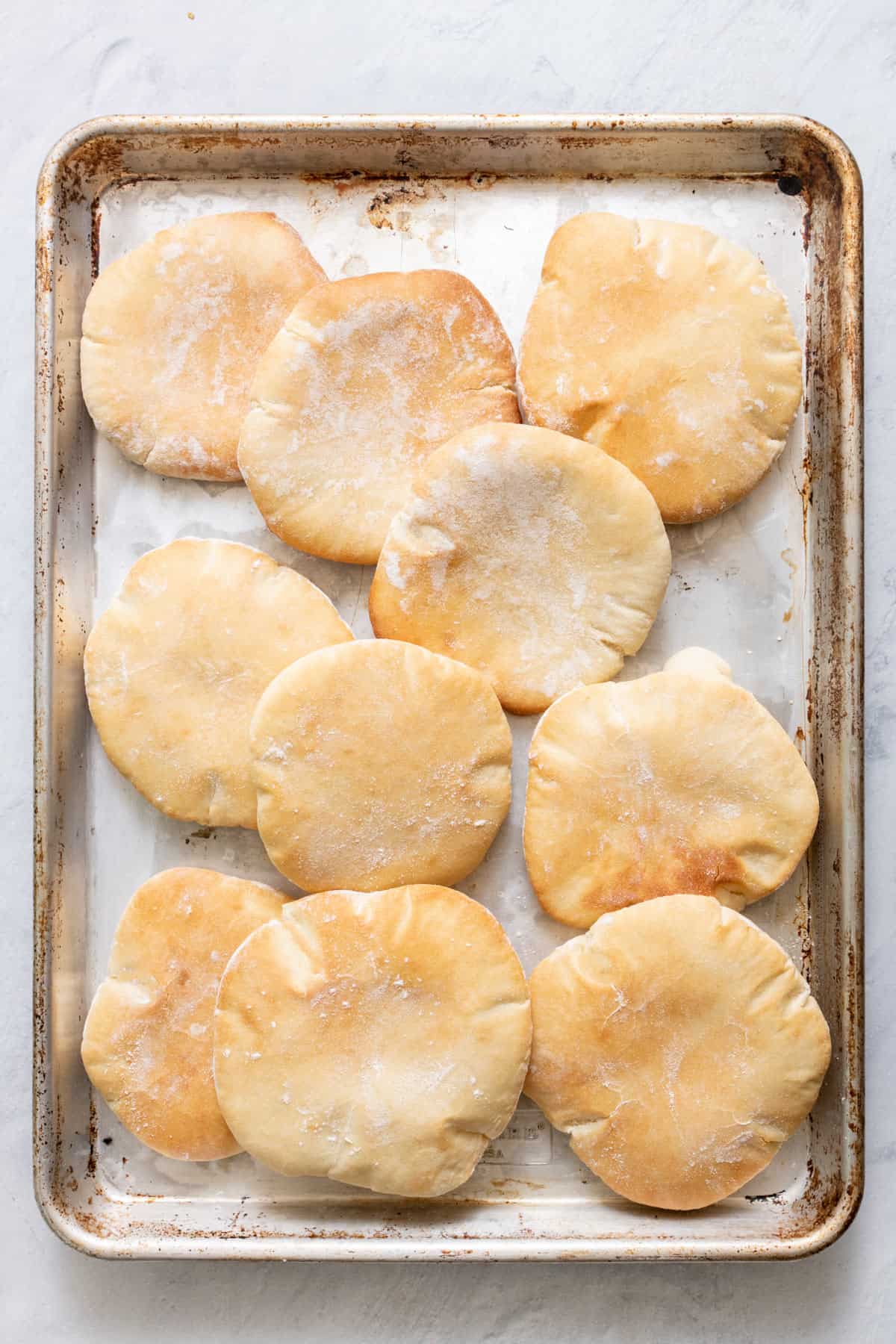 sheet pan lined with parchment paper and layered with baked homemade pita bread