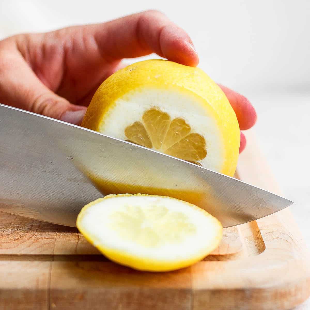 Slicing top and bottom of lemon off.