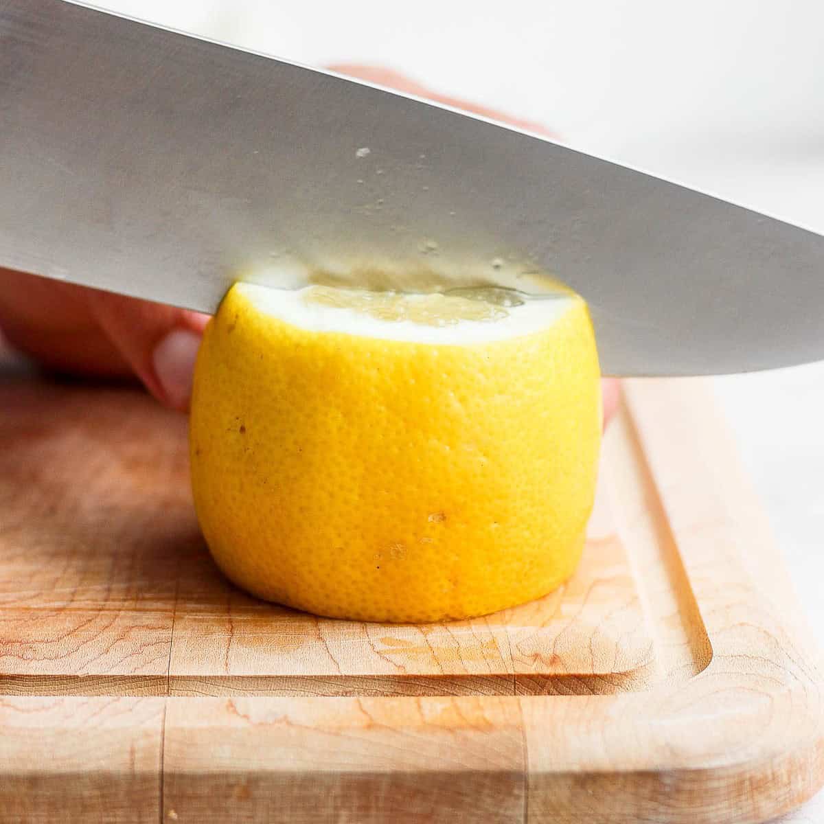 Cutting lemon in half vertically.