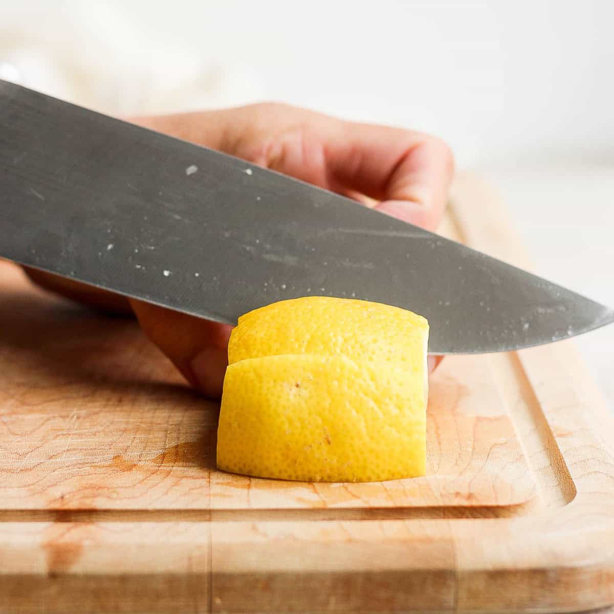 Cutting lemon into wedge.