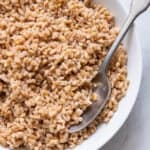 Spoon in bowl of cooked farro