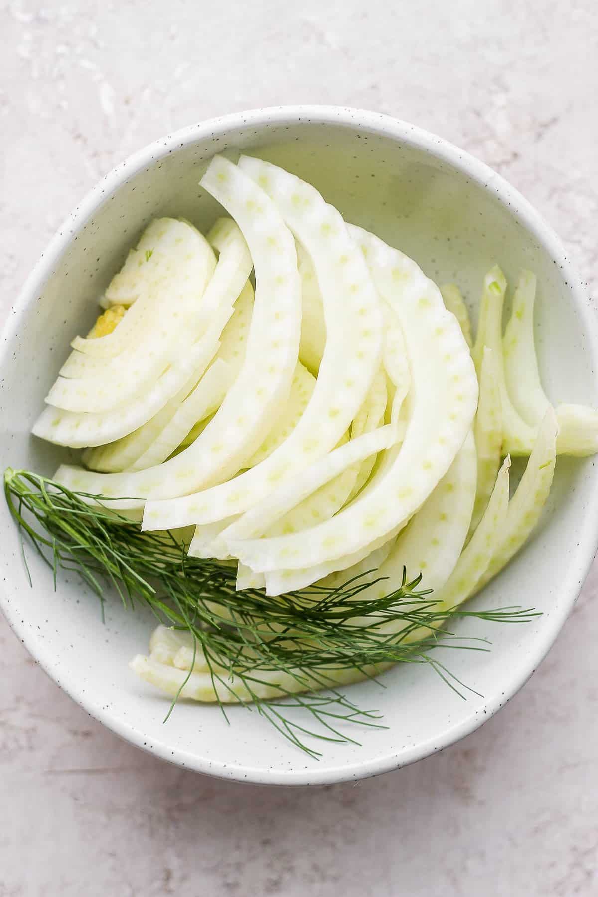Sliced fennel in a bowl with fronds included