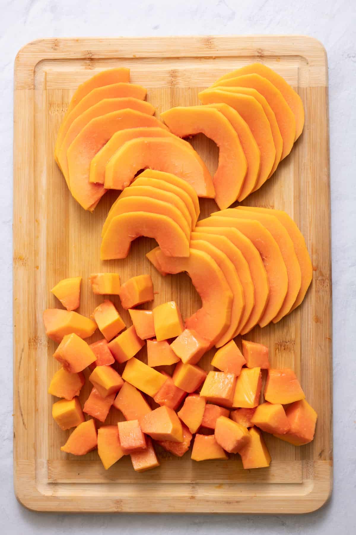 cutting board with two different ways to cut papaya