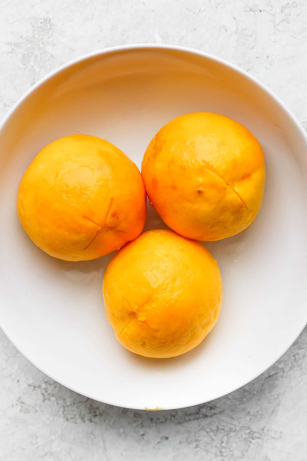Bowl of 3 fully peeled peaches