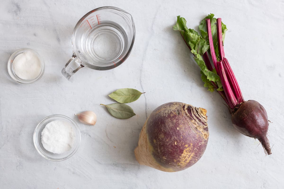 ingredients for pickling: hot water, white vinegar, kosher salf, sugar, garlic clove, bay leaves, turnips, and beet
