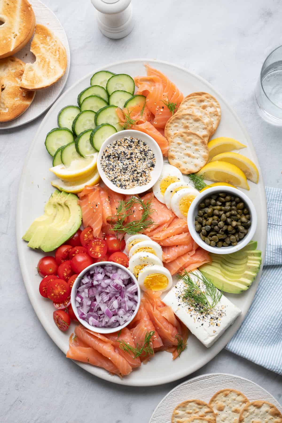 Smoked salmon platter with eggs, cucumber, avocado, tomatoes, crackers and more