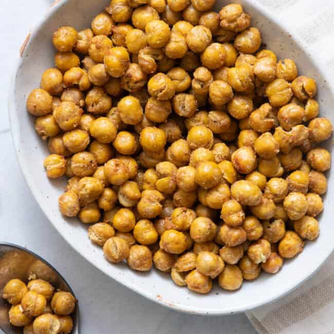 Bowl of Air Fryer Chickpeas in white oval bowl with a spoon with chickpeas.