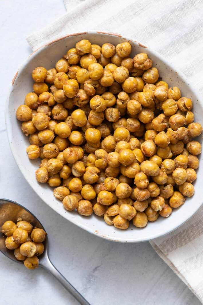 Bowl of Air Fryer Chickpeas in white oval bowl with a spoon with chickpeas.