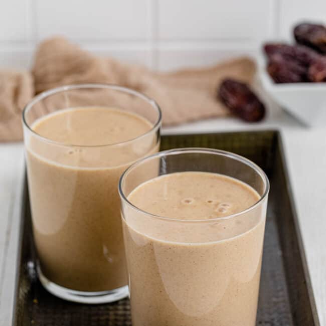 Two glasses of Banana Date Smoothie on a serving tray.