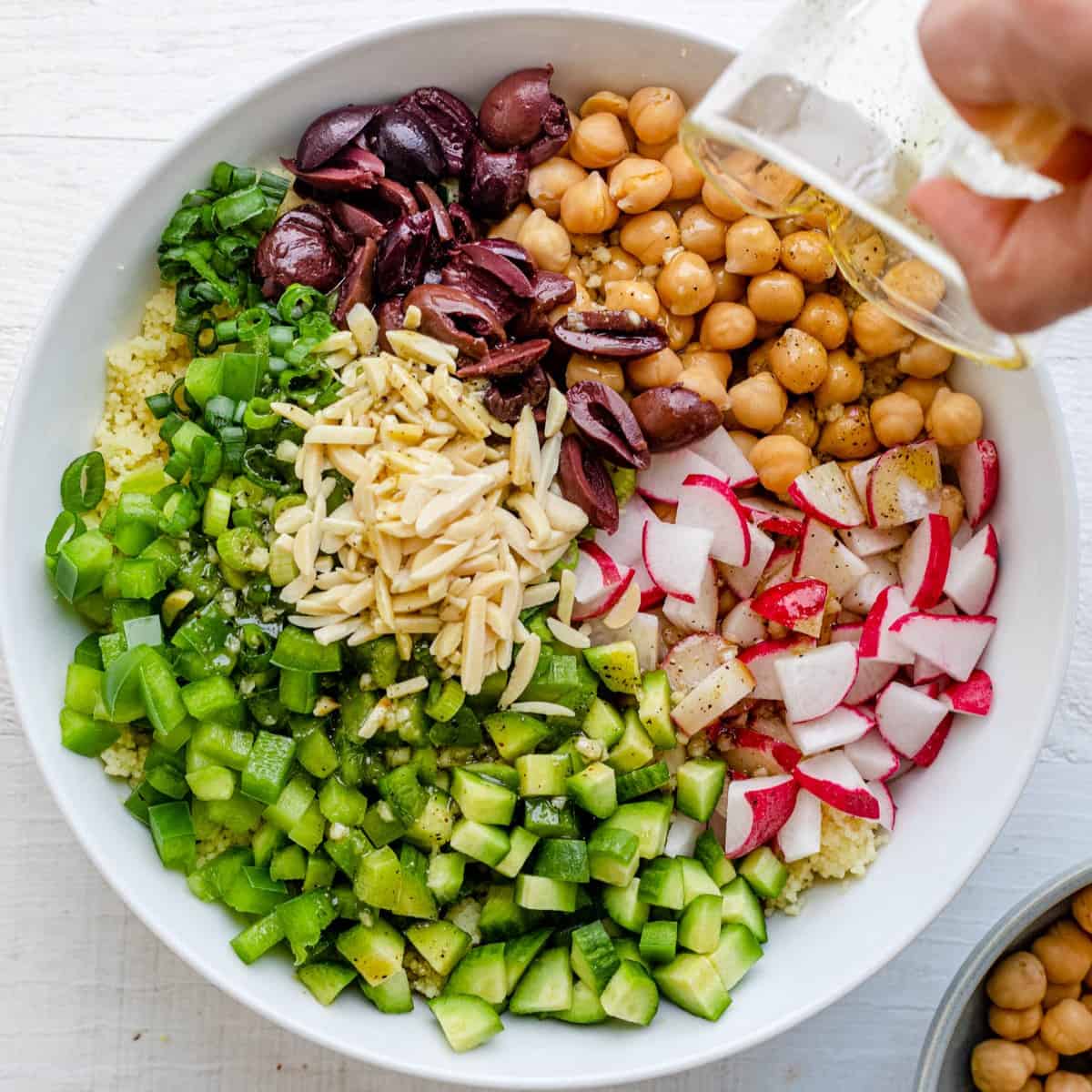 Pouring the dressing on the salad.