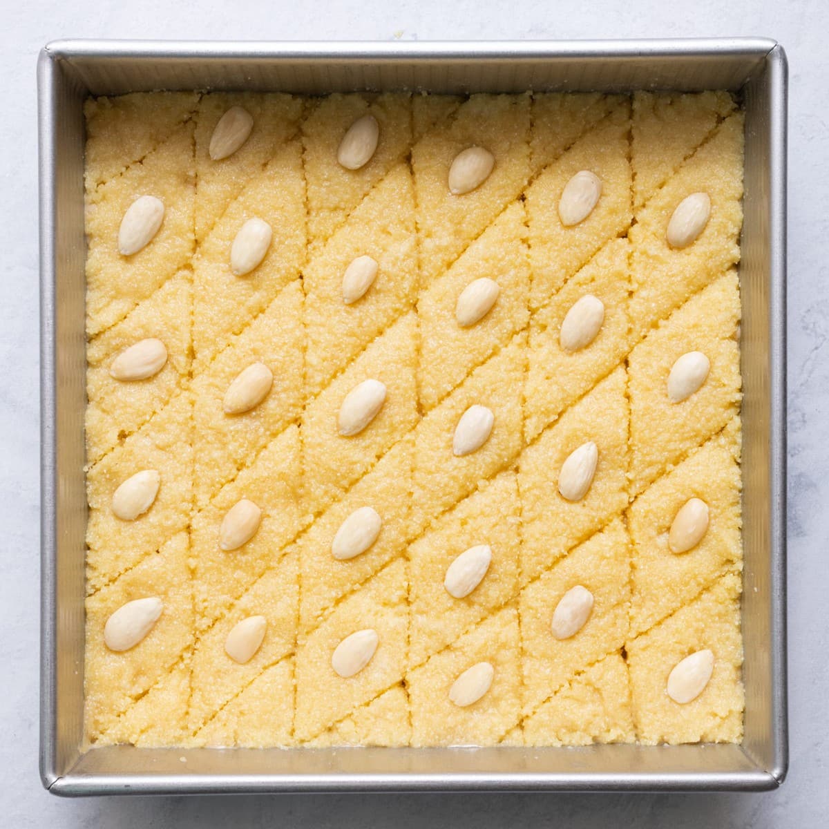 Semolina cake cut with almond added to each diamond before baking.