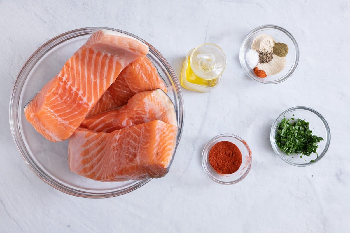 Ingredients for recipe: 4 salmon filets, oil, spices, and fresh parsley.