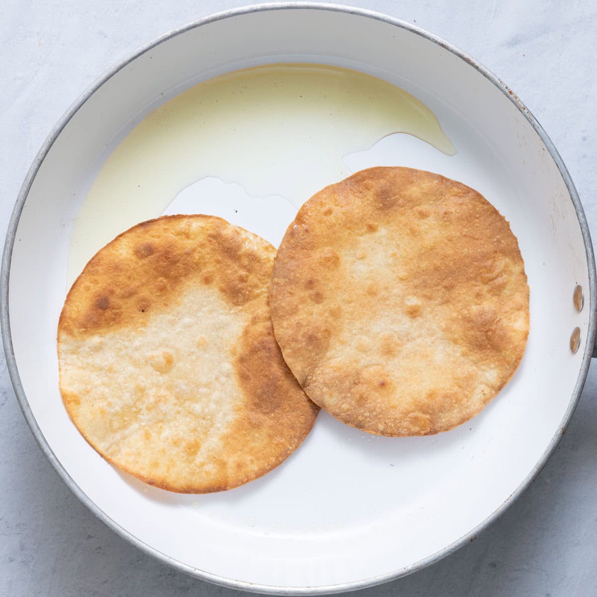 2 warmed corn tortillas on a pan.