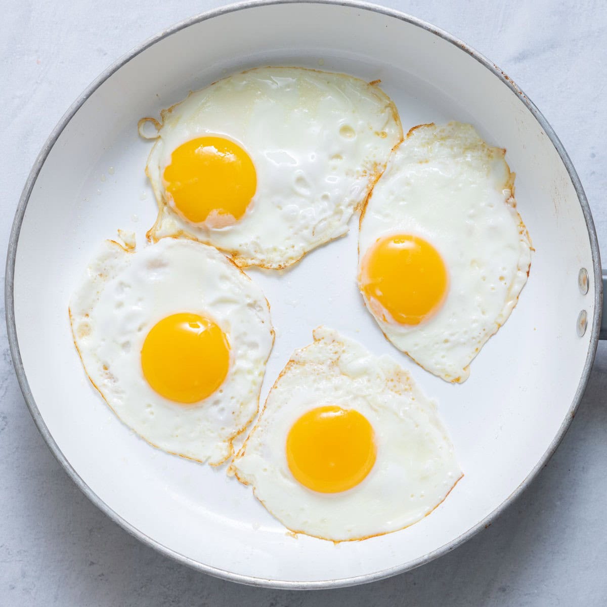 4 cooked eggs on a pan.